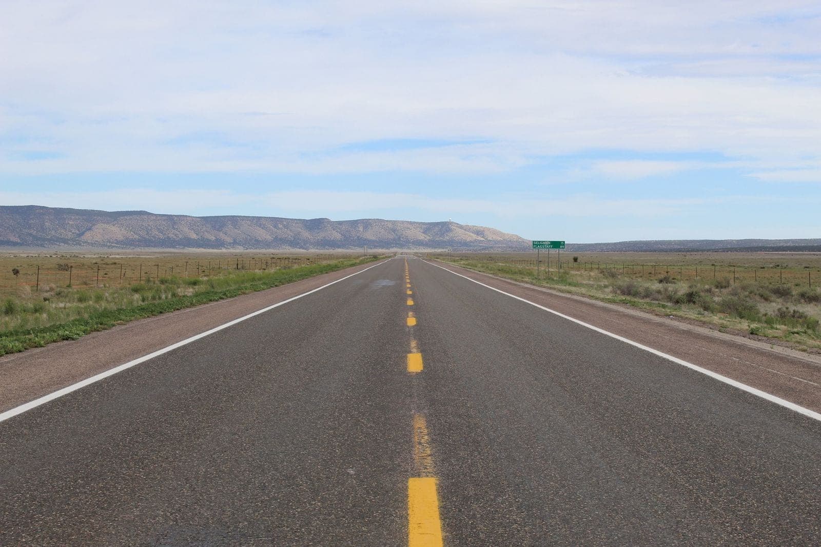 Straight highway toward distant mountains