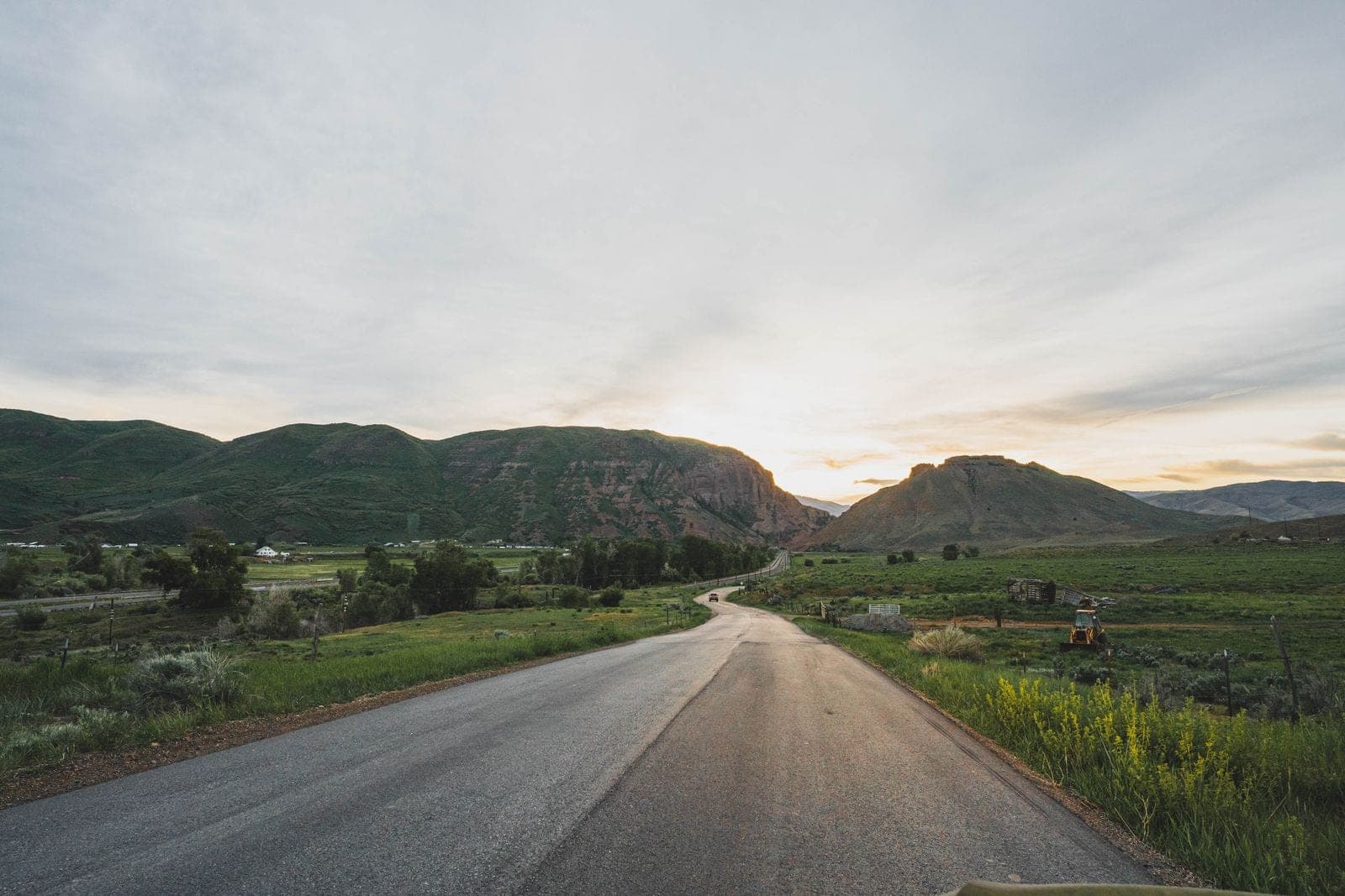 Rural road through a valley at sunset