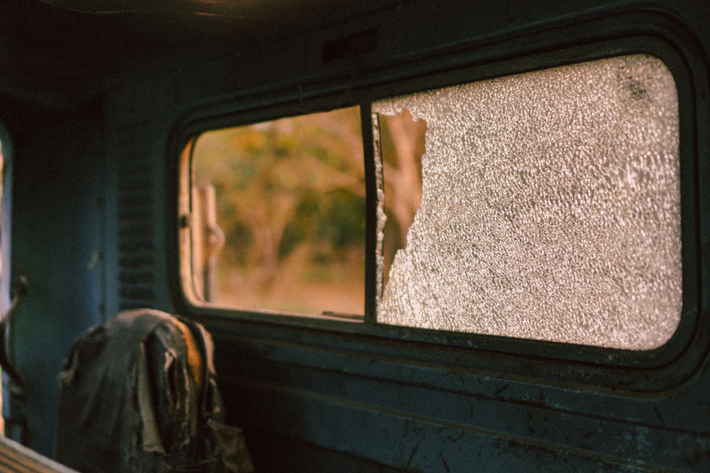 Shattered car side window seen from inside, before a car window replacement